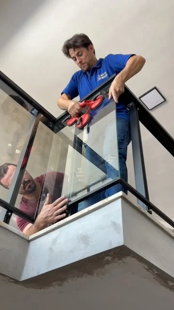 Profissionais instalando um guarda-corpo de vidro em trabalho publicado pela World Vidros